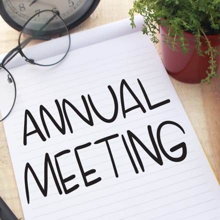 The words Annual Meeting written on a notepad resting on a table.