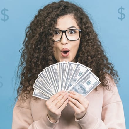 A young woman holding several $100 dollar bills.