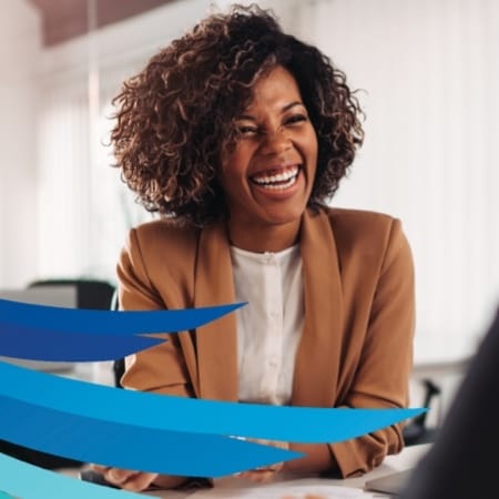 A young woman professional sitting at a table smiling.