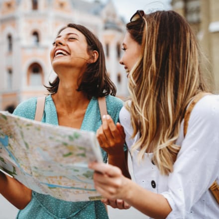 Two women travelers looking at a map.