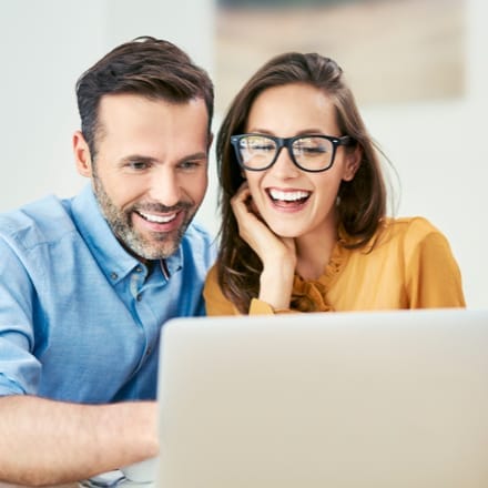 A young couple looking at a laptop.