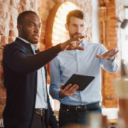 Two businessmen having a conversation in an office.