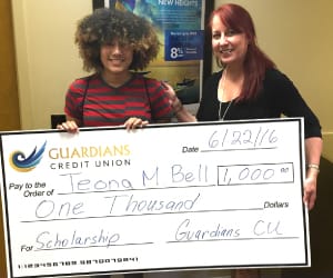 Teona Bell holding a human-sized check for $1,000