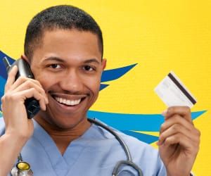A man smiling on the telephone and holding an ATM card