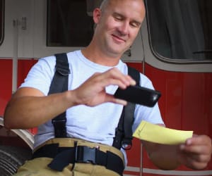 A firefighter taking a picture of a check with a smartphone.