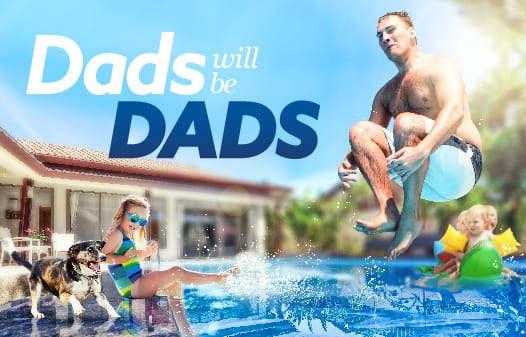 A dad jumping into a pool while his kids look and splash water.