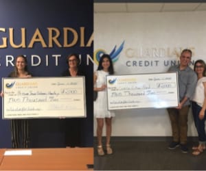 Two scholarship winners holding a human-sized check.
