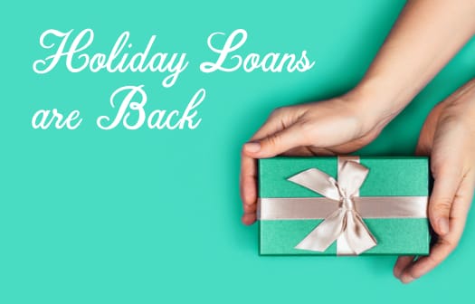 A hand holding a gift box. To the left, the words: holiday loans are back