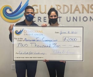 Maricarmen Torres Concepcion receiving a human sized check for $2,000.