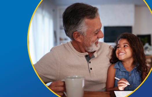 A grandfather happily holding his granddaughter while drinking coffee.