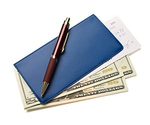 A brown pen laying over a blue checkbook