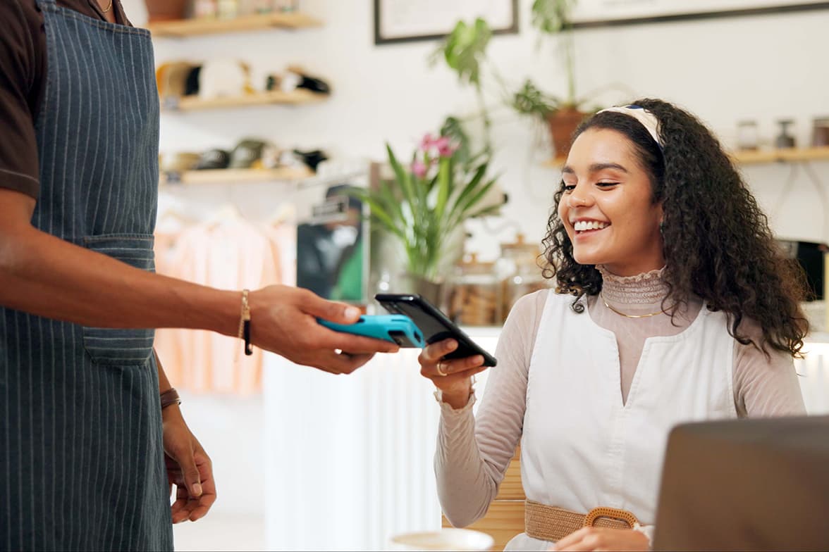 A young woman using her mobile phone to pay for services.