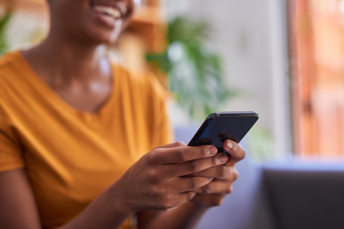 A smiling woman using a smart phone.