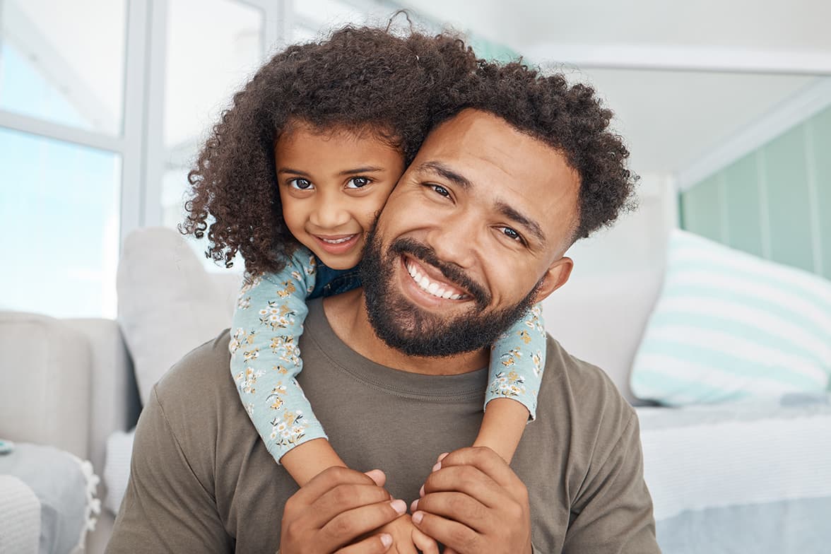 A man carrying a young girl on his back.