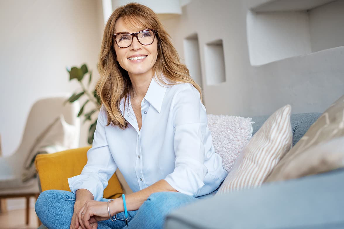 A woman sitting on a couch smiling.