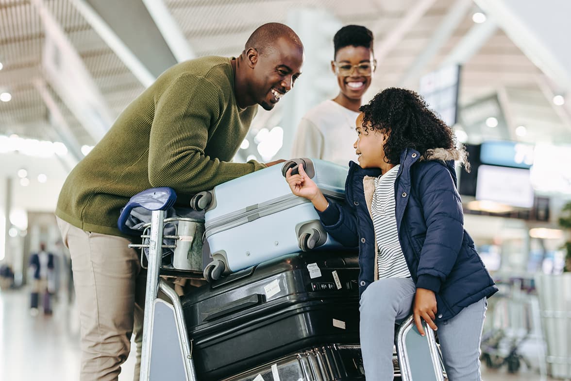 A family of three at the airport checking in bags.