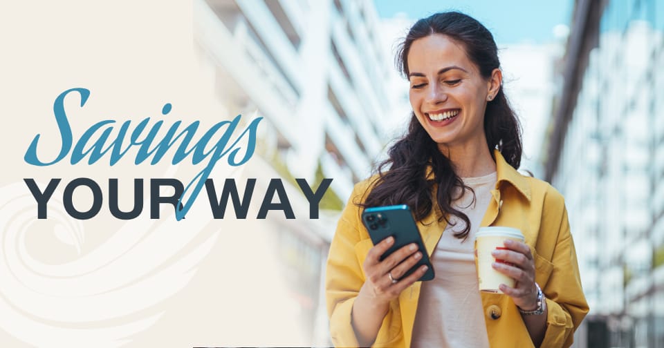 A smiling woman holding a cup of coffee and looking at her mobile device. To the left, the words: savings your way.