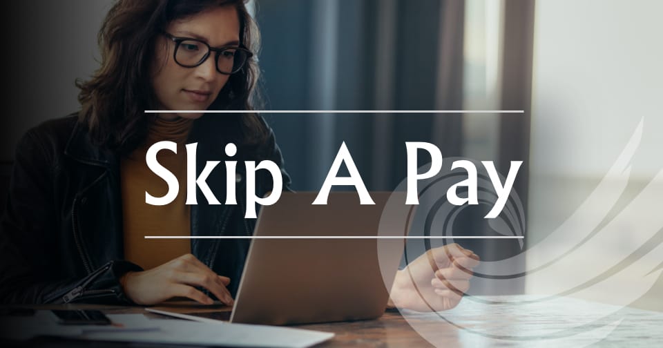 A woman using a laptop. Across the middle, the words: skip a pay.