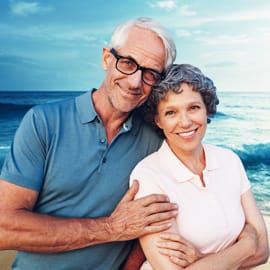 An elderly couple comforting eachother and smiling.